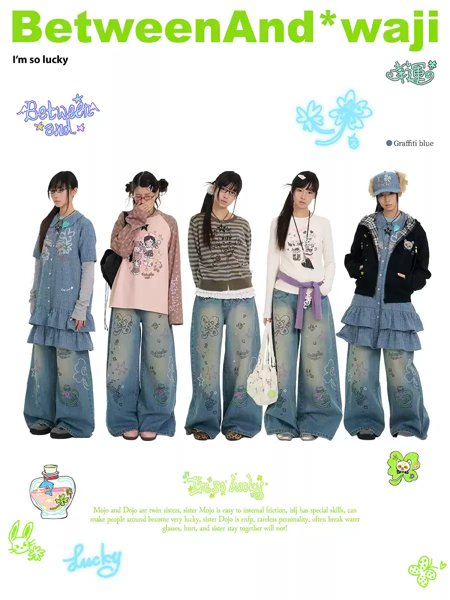 ラインストーンのディテールとウォッシュ仕上げが施されたブルーのグラフィティプリントジーンズ